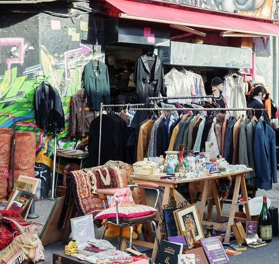 espositore al mercatino vintage di Milano in viale Papiniano, con bancarella di oggettistica e abbigliamento d'epoca