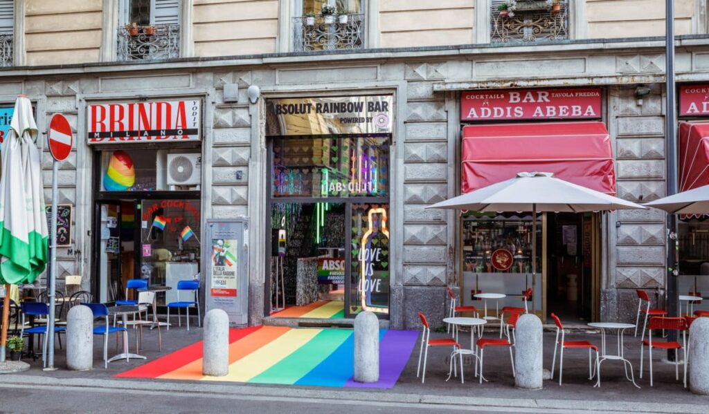 foto della strada di via Lecco a Milano, con i bar a tema LGBTQ+ e colorati con i colori arcobaleno. 