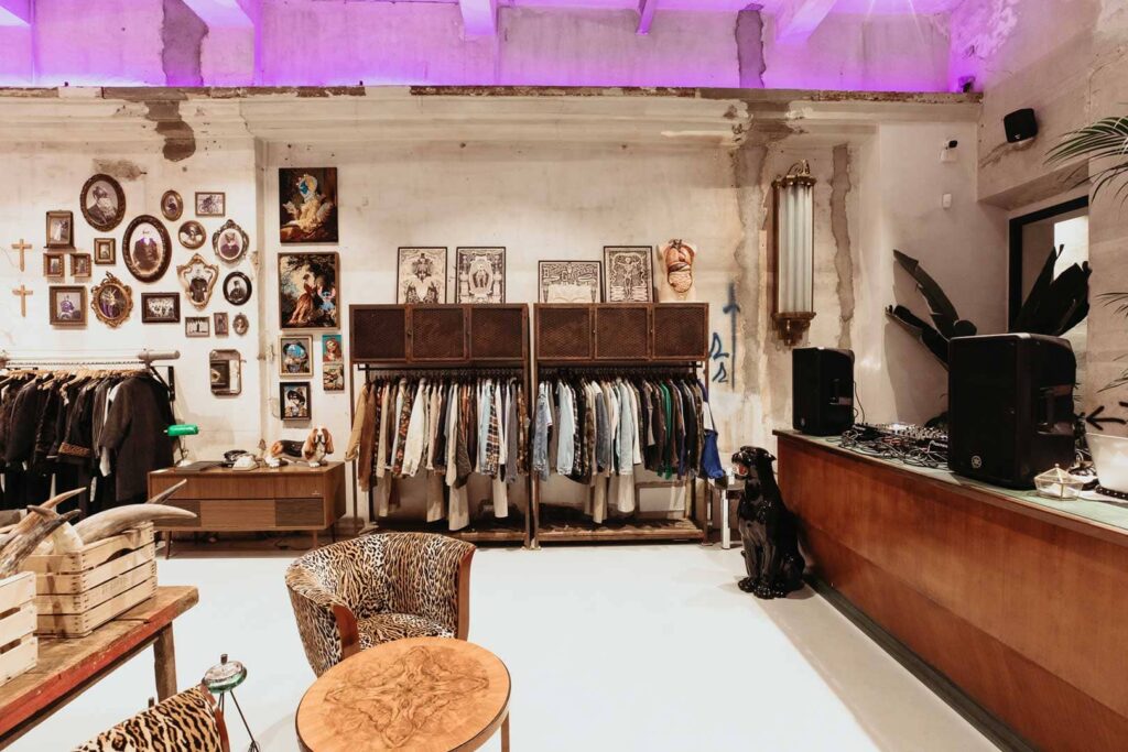 interno del negozio vintage East Market. Luci viola, oggettistica, abbigliamento e antiquariato. 